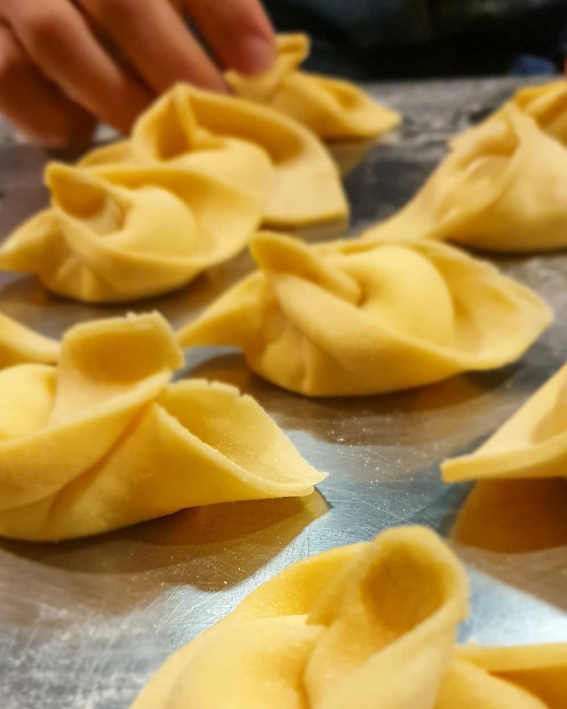 Hand-folded ravioli on a floured bench